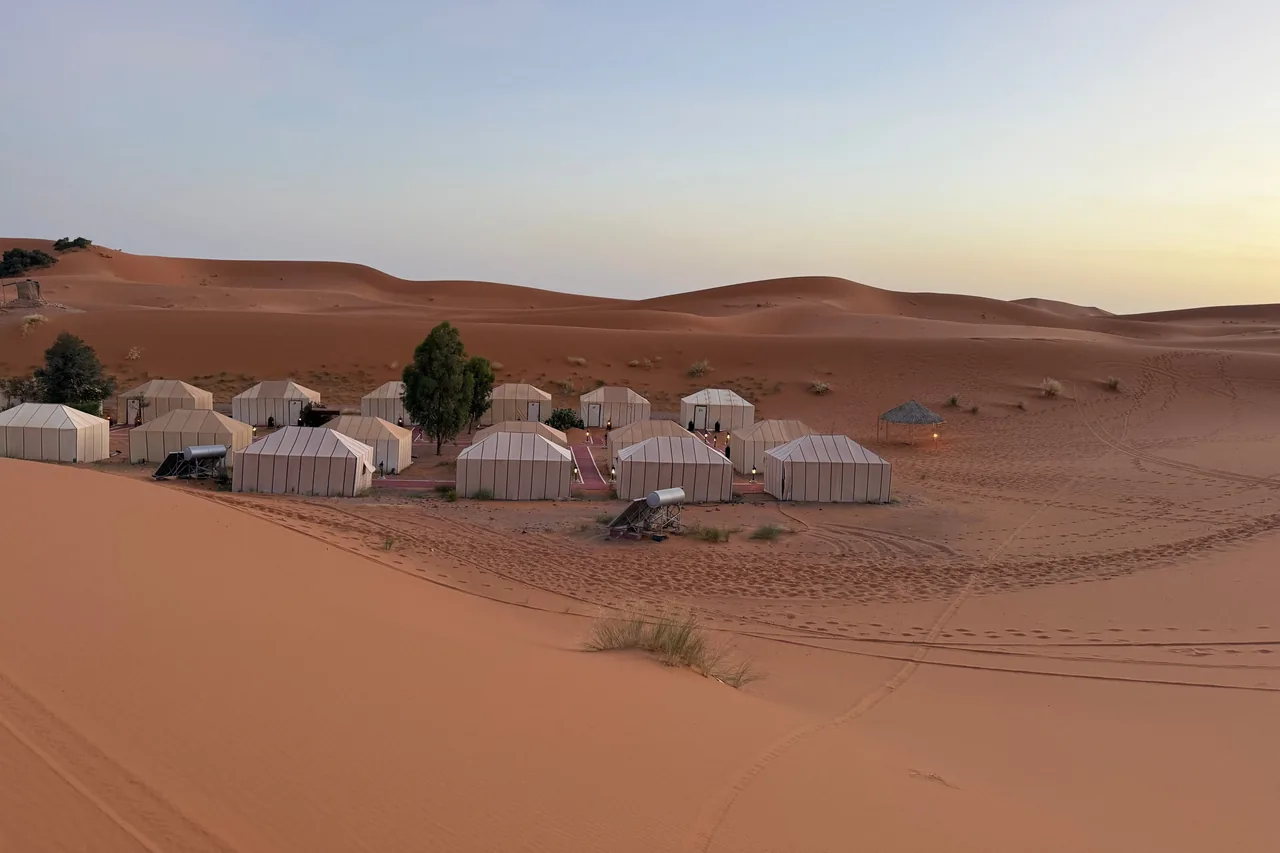 Canvas tents at the foot of desert dunes